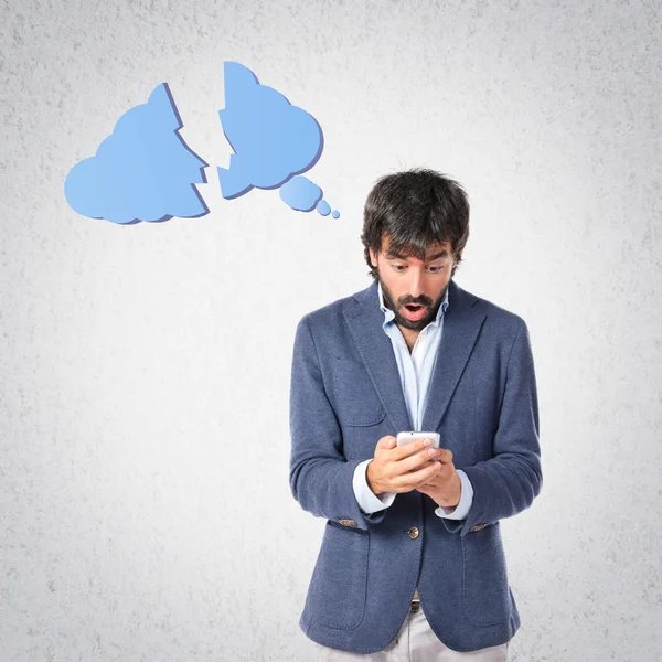 Hombre sorprendido hablando con móvil sobre fondo gris — Foto de Stock