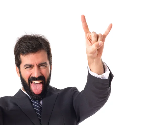 Businessman making horn gesture over white background — Stock Photo, Image