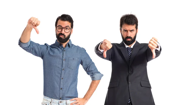 Twin brothers doing bad signal over white background — Stock Photo, Image