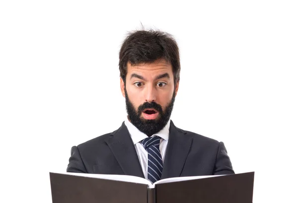 Uomo d'affari sorpreso di leggere un libro su sfondo bianco — Foto Stock