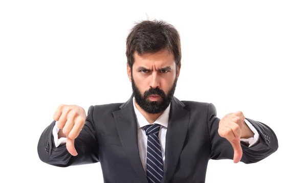 Empresario haciendo una mala señal sobre fondo blanco — Foto de Stock