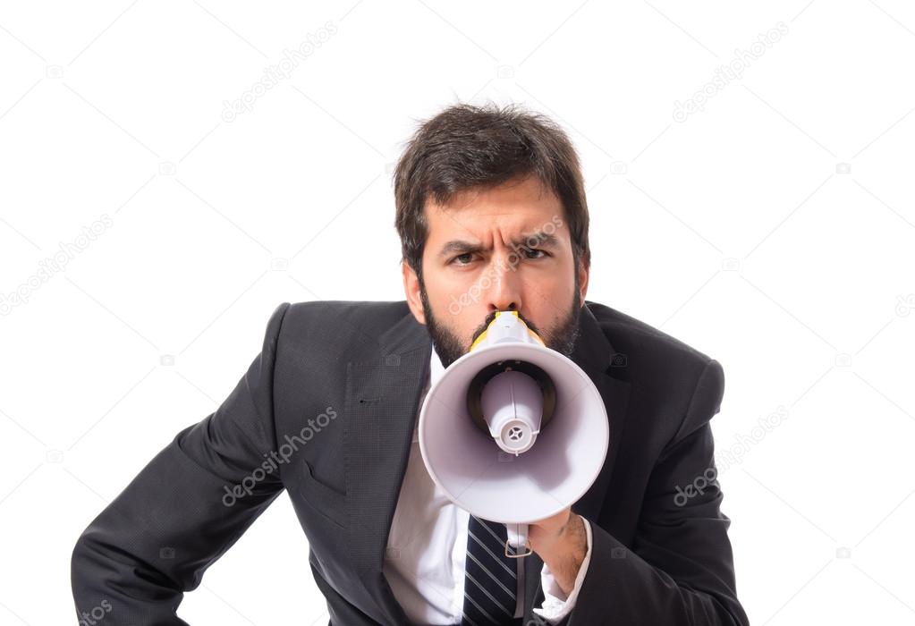 Businessman shouting by megaphone over white background