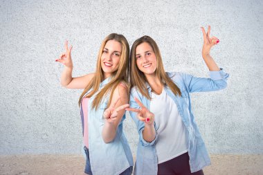 dokulu arka plan üzerinde zafer jest yapıyor kızlar