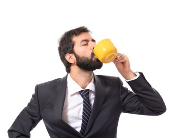 Bir fincan kahve beyaz arka plan üzerinde tutan işadamı