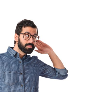 Beyaz arka plan üzerinde dinleme genç hipster adam 