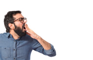 Beyaz arka plan üzerinde esneme genç hipster adam 