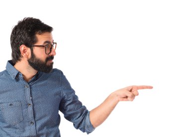 Genç hipster adam işaret lateral beyaz arka plan üzerinde