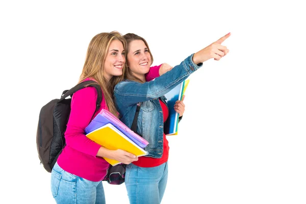Estudante mulheres apontando para o lateral sobre fundo branco — Fotografia de Stock