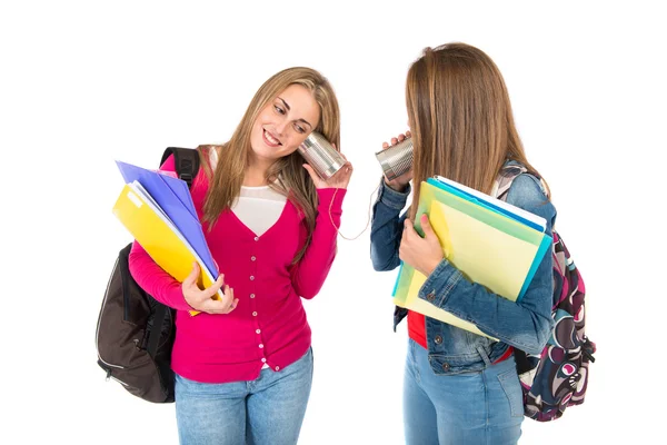 Students talking through a tin phone over white background — Stock Photo, Image