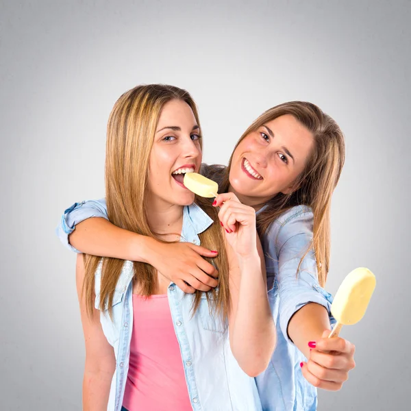 Amigos comendo sorvete sobre fundo cinza — Fotografia de Stock