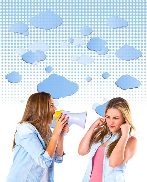 Girl shoutimg with a megaphone at her friend — Stock Photo, Image