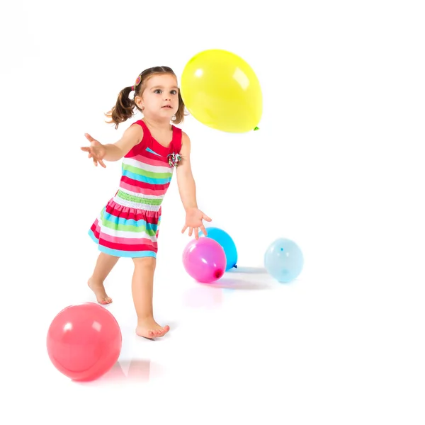 Kid playing with balloons over white background — Stock Photo, Image