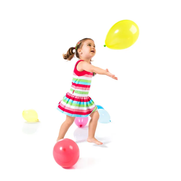 Kid playing with balloons over white background — Stock Photo, Image