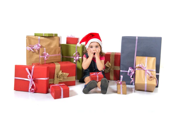 Blonde christmas kid around several presents doing surprise gesture — Stock Photo, Image