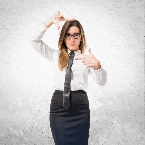 Bonita mujer de negocios enfocándose con los dedos en un fondo blanco — Foto de Stock