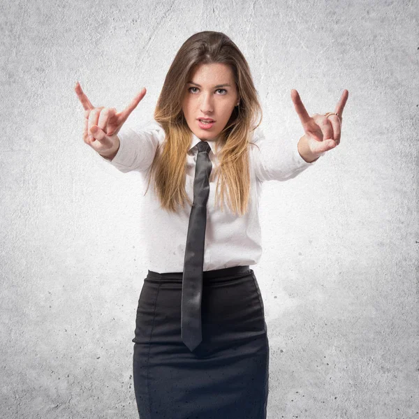 Young businesswoman making horn gesture over white background — Stock Photo, Image