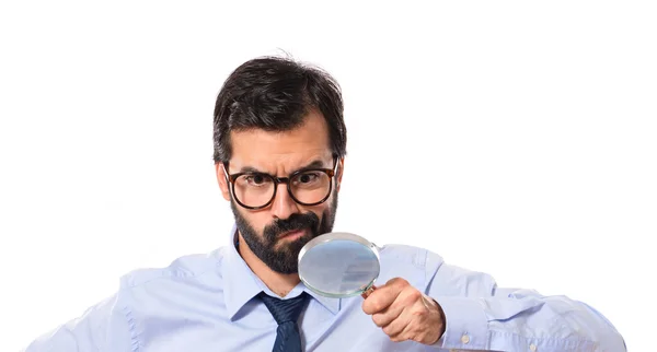 Businessman with magnifying glass over white background — Stock Photo, Image