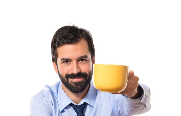 Empresário segurando uma xícara de café sobre fundo branco — Fotografia de Stock