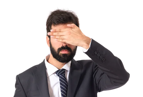 Businessman covering his eyes over isolated white background — Stock Photo, Image