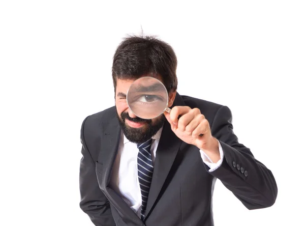 Businessman with magnifying glass over white background — Stock Photo, Image