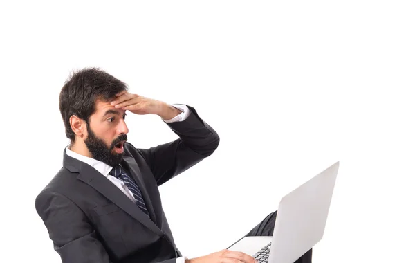 Verrast zakenman met laptop op witte achtergrond — Stockfoto
