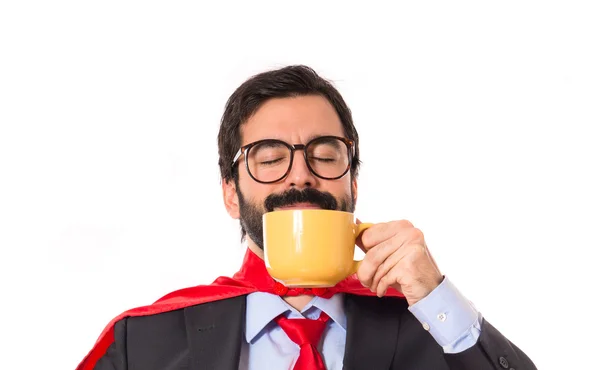 Zakenman gekleed als superheld drinken koffie — Stockfoto