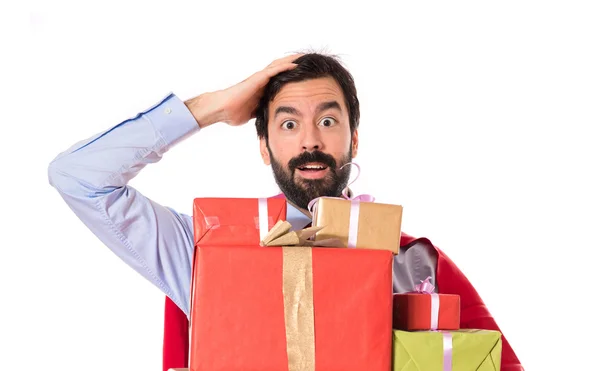 Surprise businessman dressed like superhero holding gifts — Stock Photo, Image