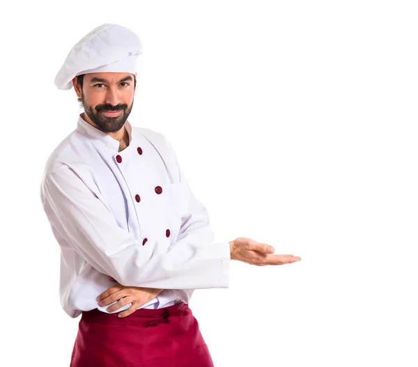Koch präsentiert etwas vor weißem Hintergrund — Stockfoto