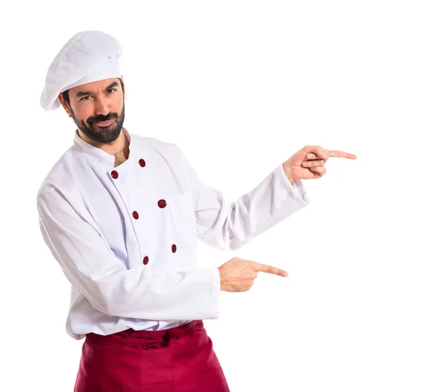 Шеф-повар указывает на боковую сторону на белом фоне — стоковое фото
