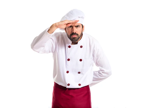Koch zeigt etwas vor weißem Hintergrund — Stockfoto