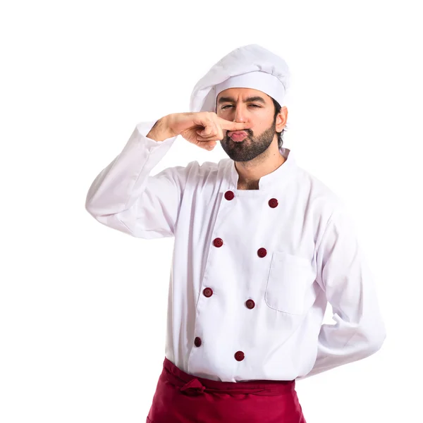 Szef kuchni robi gest wąsy na tle shite — Zdjęcie stockowe