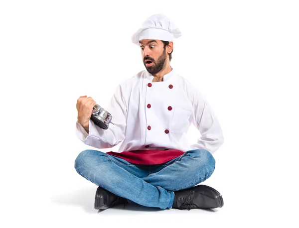 Удивленный шеф-повар держит часы на белом фоне — стоковое фото