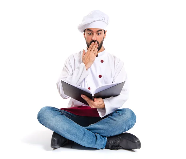 Удивленный шеф-повар, читающий книгу — стоковое фото