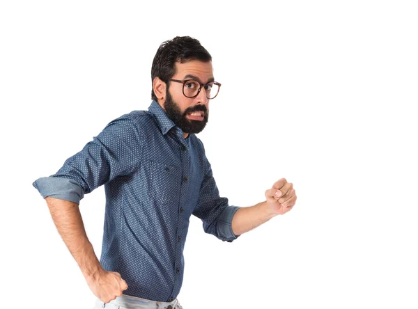 Joven hipster hombre corriendo rápido sobre fondo blanco — Foto de Stock