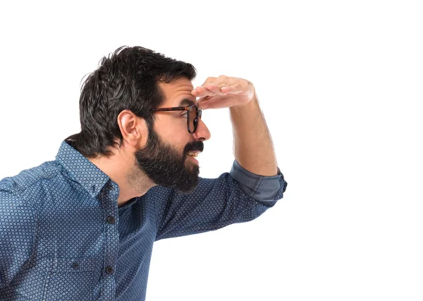 Mladá bederní muž ukazuje něco nad bílým pozadím — Stock fotografie