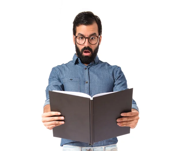 Förvånad hipster man läser en bok — Stockfoto