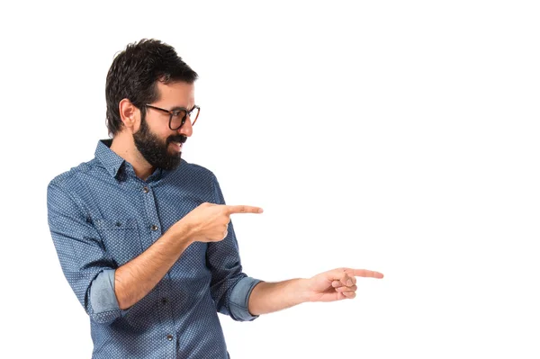 Young hipster man pointing lateral over white background — Stock Photo, Image