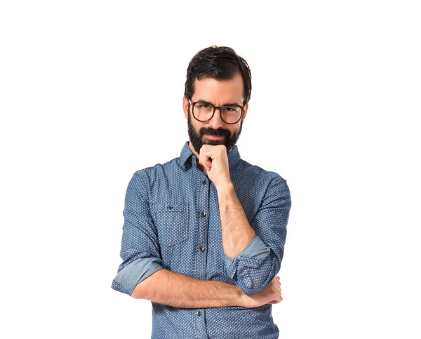 Joven hipster hombre pensando sobre fondo blanco — Foto de Stock