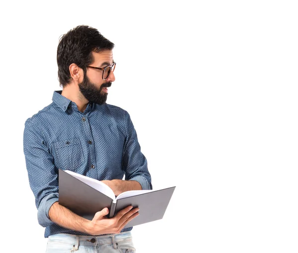 Joven hipster hombre mostrando libro sobre fondo blanco —  Fotos de Stock