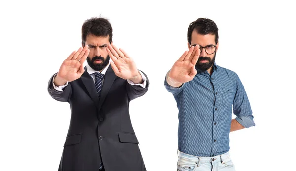 Twin brothers making stop sign over white background — Stock Photo, Image