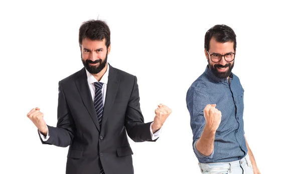 Zwillingsbrüder machen Siegesgeste vor weißem Hintergrund — Stockfoto