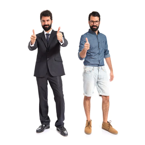 Hermanos gemelos haciendo gesto de victoria sobre fondo blanco —  Fotos de Stock