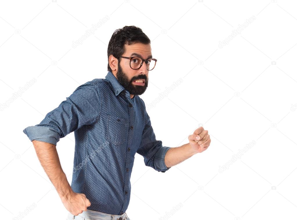 Young hipster man running fast over white background