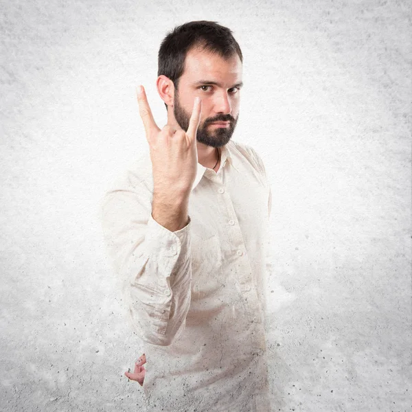 Junger Mann beim Hupen vor weißem Hintergrund — Stockfoto