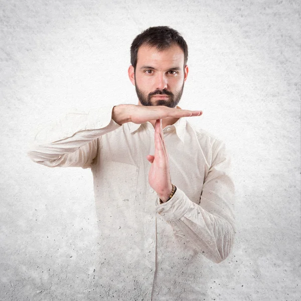 Joven haciendo el letrero del tiempo de espera sobre fondo blanco — Foto de Stock