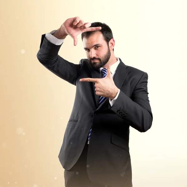 Joven hombre de negocios haciendo un letrero marco sobre fondo blanco — Foto de Stock