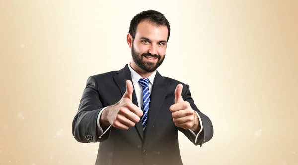 Joven hombre de negocios recibiendo OK sobre fondo blanco — Foto de Stock