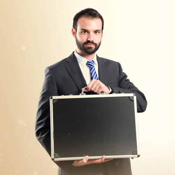 Young businessman with his briefcase over white background — Stock Photo, Image