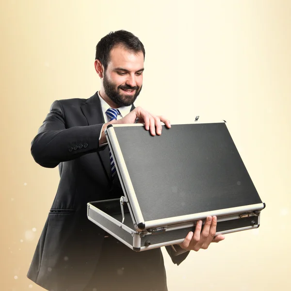 Young businessman open his briefcase over white background — Stock Photo, Image