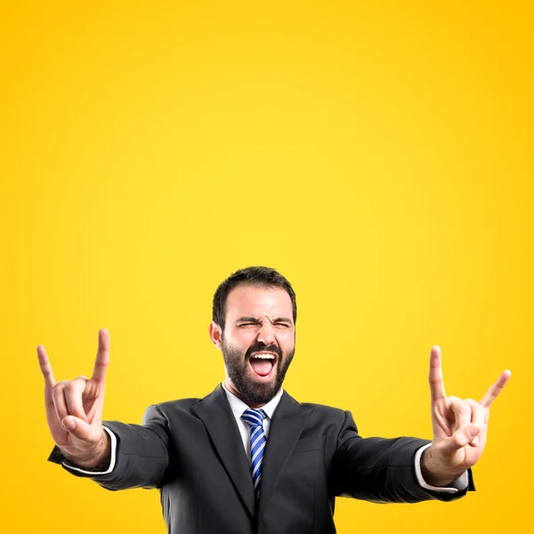 Jonge zakenman doen de hoorn bord boven gele achtergrond — Stockfoto